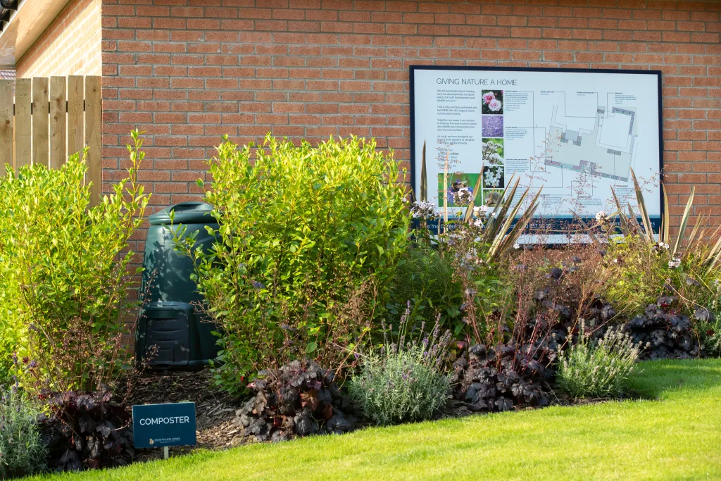 Barratt Developments composter with the site map on the wall amongst plants.