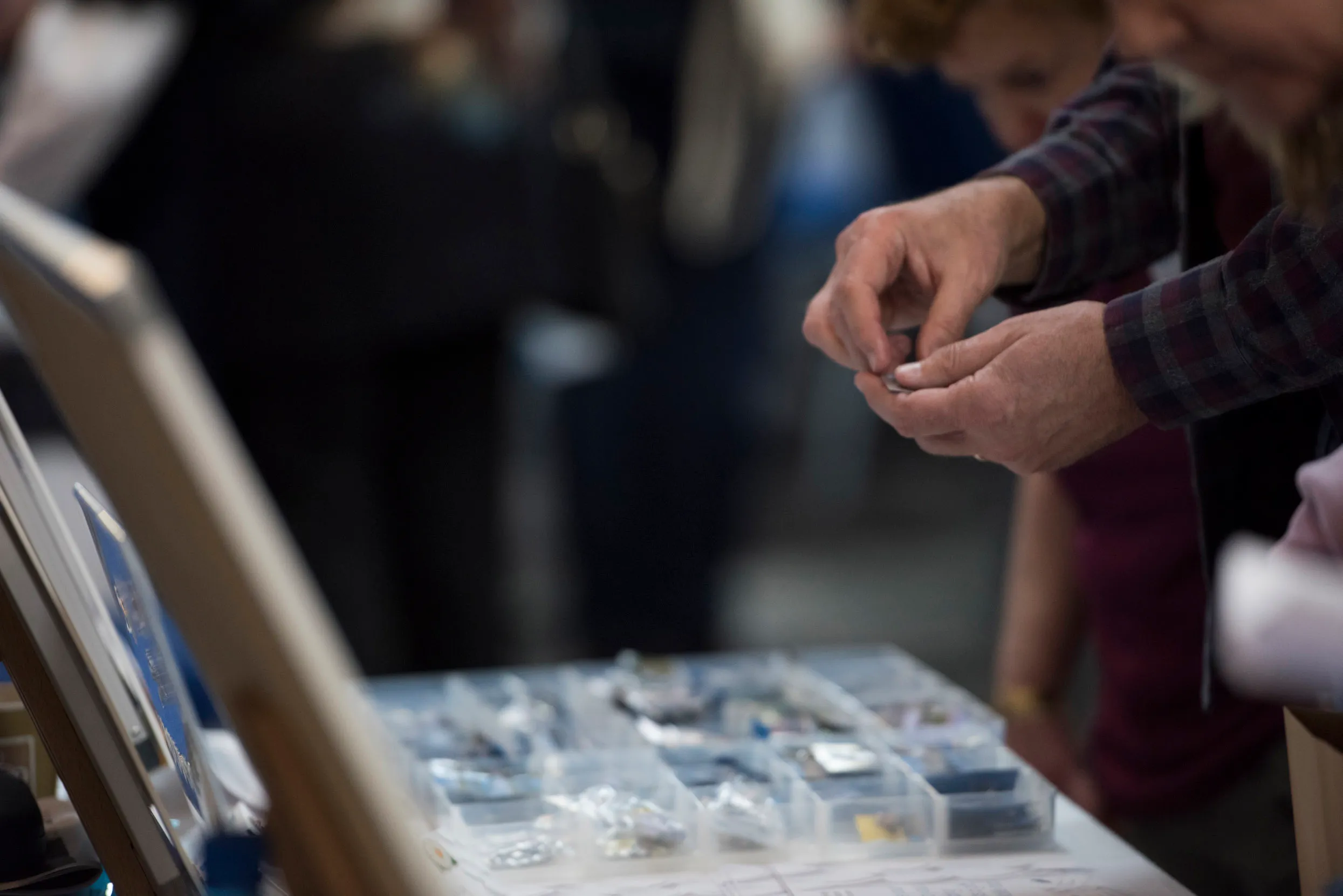 People stood at an RSPB pin badge stall, inspecting the pin badges for sale.