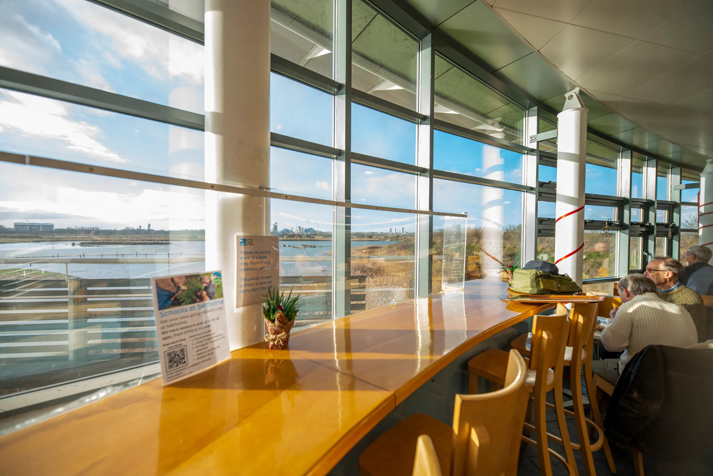 Visitors at Saltholme café, taking in the view of the water out of the large, curved windows.