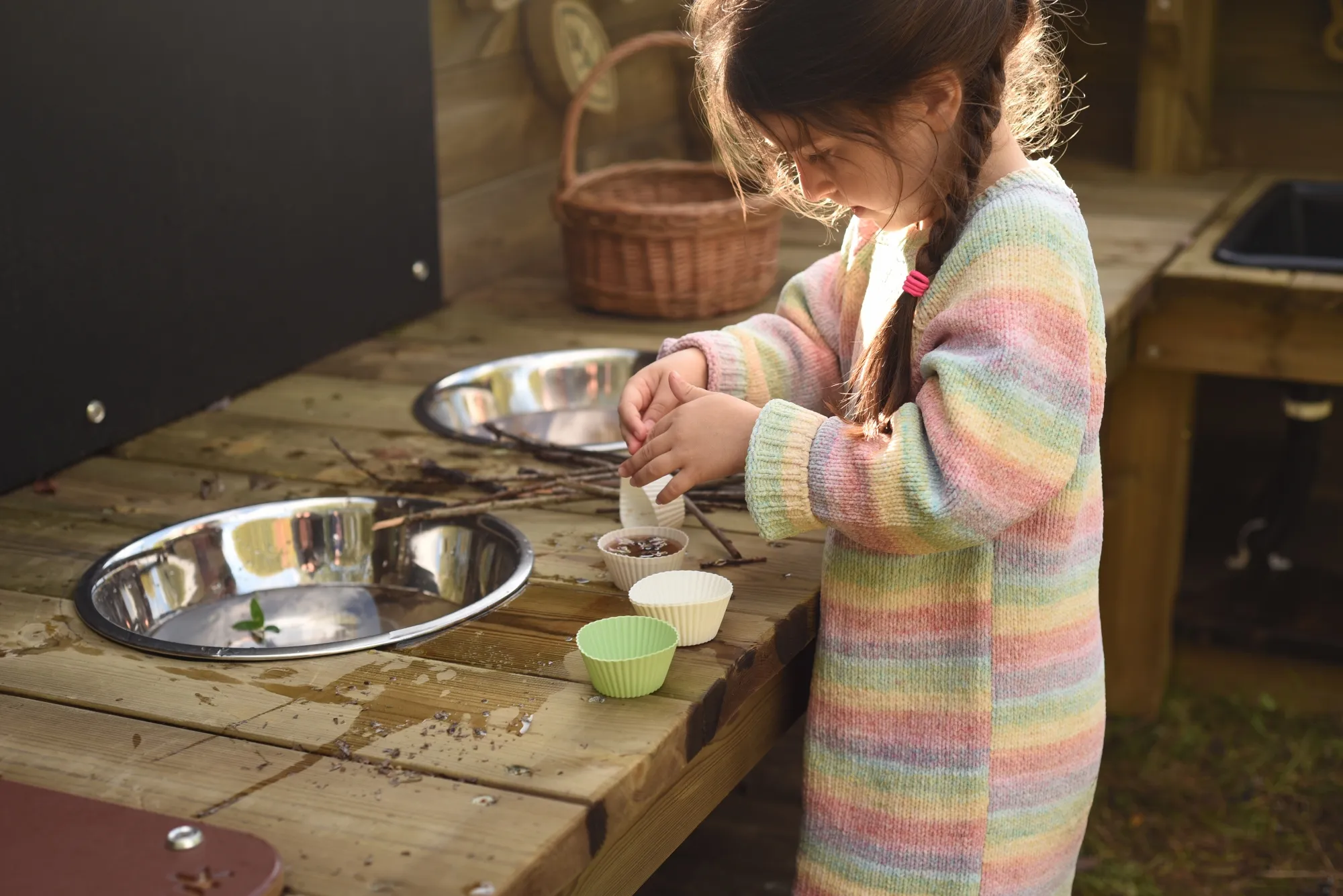 Girl playing with mud kitchen
