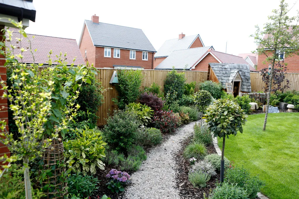 Barratt Developments garden with a trail of gravel and a fence.